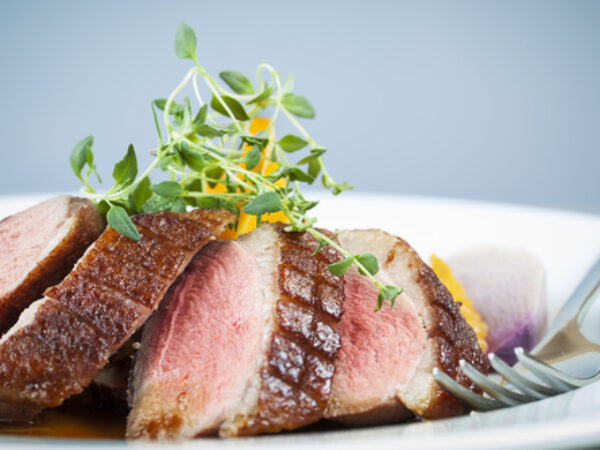 Private chef prepared duck breast with micro greens for garnish